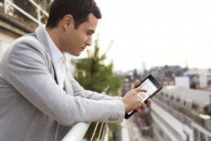 Young Man Using Venue 8 Pro Tablet Outside On Balcony